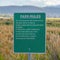 Square Green sign board with Park Rules against lush tall grasses on a vast terrain