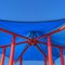 Square Hexagon shaped blue roof supported by red poles against vibrant sky