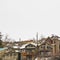 Square Hill homes with balconies and snowy roofs against cloudy sky in winter