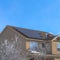 Square Home along Wasatch Mountain terrain with solar panels on the pitched roof