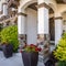 Square Home with an arched entrance and vibrant plants and flowers at the facade