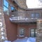 Square Home with balcony over snowy entrance built on Wasatch Mountain neighborhood