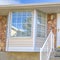 Square Home with a beautiful glass paned door and half hexagon shaped window