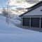 Square Home exetrior with paved driveway leading to the three door garage entrance