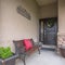 Square Home facade with bench welcome sign and potted plants on the porch