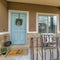 Square Home featuring blue front door and open porch with steps and curved railing