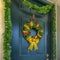 Square Home with a sunlit porch and front door decorated with wreath and garland