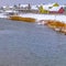 Square Homes near a lake with snowy and grassy shore