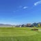 Square Homes and pathway on a vast field overlooking a lake and snow topped mountain