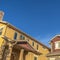 Square Homes with porches gable roofs and brick chimneys against vibrant blue sky