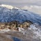 Square Homes on snowy terrain of Wasatch Mountains with sunlit peak in the background