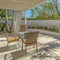 Square House with an outdoor eating area on the patio with white curtains