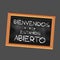 Square illustration in Spanish Welcome We\\\'re Open on a black slate with a grey background