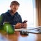 Square image of young man texting on his mobile phone