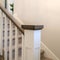 Square Indoor staircase of a home with white balusters brown handrail and newel