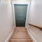Square Indoor stairs of home with carpeted treads that leads down to the basement door