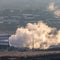 Square Industrial plant emitting thick smoke against foggy landscape in winter