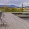 Square Lake with wooden deck and benches overlooking houses beyond the grassy shore