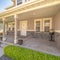 Square Landscaped yard and pathway in front of porch and white front door of home