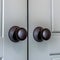 Square Matte black round door knobs of a double door with paneling inside a home