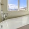 Square New house with a gleaming white bathtub inside the sunlit bathroom