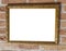 Square old vintage golden blank painting frame work hanging on a brick wall close up