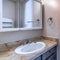 Square Oval sink on marble countertop with cabinet inside bathroom of home