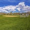 Square Panorama of a soccer field with houses and mountain in the distance