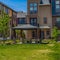 Square Patio on a lawn surrounded by townhouses with bright blue sky overhead