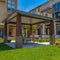 Square Patio with table and seats under the a roof supported by four pillars