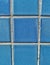 Square pattern blue tiled wall. Blue pool tiles. Dark blue small tiles on a wall. Facade of bathroom. Parede de azulejos azuis.