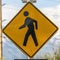 Square Pedestrian Crossing sign Crosswalk lights and Diagonal Arrow sign beside a road