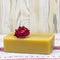 A square photo of dry red romantic rose flower and natural handmade organic olive oil soap on the wooden table. Rustic background.