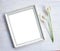 Square photo frame with flower. Photoframe or picture frame mockup. Clean feminine table flat layout. Empty frame mock-up for