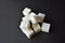 Square pieces of refined sugar on a black background