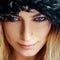 Square portrait of cutie young woman with blond hair and blue eyes in fur hat