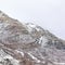 Square Provo Canyon mountain with steep rugged slopes dusted with snow in winter