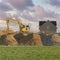 Square Puffy clouds at sunset Construction sand piles with two excavators at Utah