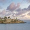 Square Puffy clouds at sunset La Jolla rocky coastal lines with beach front homes in Californi