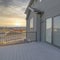 Square Puffy clouds at sunset Sliding glass door on a balcony deck of a gray house