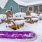 Square Purple sled and wooden chairs surrounded by snow during winter in Daybreak