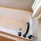 Square Rectangular bathtub with black faucet and handles against tile wall and floor
