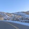 Square Road in Park City passing along snowed in mountain slopes with homes and trees
