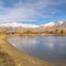 Square Scenic panorama of a lake against snow capped mountain and blue sky in winter
