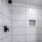 Square Shower stall with mosaic tiles flooring and marble tiles surround with black grout