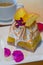 Square slice of fancy lemon meringue dessert garnished with yel