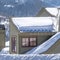 Square Snow covered pitched roof top of home against blurry mountain and sky in winter