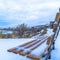 Square Snowy hilly terrain by the frosted Utah Lake in winter with empty outdoor bench