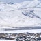 Square Snowy rooftops of homes with a striking view of snow covered mountain in winter