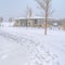 Square Snowy trail along Oquirrh Lake with view of a clubhouse and arched bridge